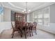 Elegant dining room with a large window, chandelier, and wainscoting at 1057 Cotton Oak Dr, Lawrenceville, GA 30045