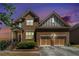 Beautiful two-story brick home with a two-car garage, landscaped yard, and evening sky at 1057 Cotton Oak Dr, Lawrenceville, GA 30045