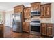 Kitchen with stainless steel appliances, wooden cabinets, granite countertops, and hardwood floors at 1057 Cotton Oak Dr, Lawrenceville, GA 30045