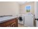 Laundry room showcasing a sink, wooden cabinets and modern washer and dryer units at 1057 Cotton Oak Dr, Lawrenceville, GA 30045