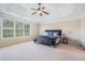 Spacious main bedroom featuring a tray ceiling, ceiling fan, and large windows at 1057 Cotton Oak Dr, Lawrenceville, GA 30045