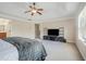 Bright primary bedroom with a tray ceiling, carpeted floor, and a TV sitting on a stand at 1057 Cotton Oak Dr, Lawrenceville, GA 30045