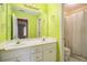 Bathroom with lime green walls, a double sink vanity, and shower with patterned curtain at 2118 Sableshire Se Way, Conyers, GA 30013