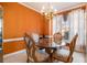 Dining room with a glass table, orange walls, and a vintage chandelier at 2118 Sableshire Se Way, Conyers, GA 30013