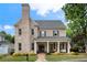 Charming brick two-story home with a covered front porch, columns, and a professionally landscaped yard at 215 Scott Xing, Roswell, GA 30076