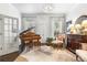 Formal living room with piano, decor, chandelier, hardwood floors, and large windows at 215 Scott Xing, Roswell, GA 30076