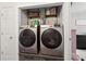 Convenient laundry area with modern washer and dryer units installed with shelving offering storage at 3618 Berkeley Ct # Iv-A, Duluth, GA 30096
