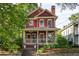 Attractive two-story red home featuring a welcoming front porch and stone retaining wall at 604 Mead Se St, Atlanta, GA 30312