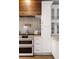Modern kitchen with stainless steel appliances, white cabinets, wooden accents, and marble backsplash at 604 Mead Se St, Atlanta, GA 30312