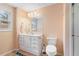 Well-lit bathroom with a single vanity, toilet, and glass-enclosed shower at 7010 Beloit Pl, Roswell, GA 30075