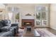 Living room featuring a fireplace, hardwood floors, and large windows at 7010 Beloit Pl, Roswell, GA 30075
