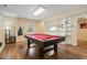 Finished basement game room with pool table, built-in shelving, and exterior access at 7010 Beloit Pl, Roswell, GA 30075