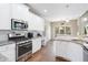 Bright kitchen features granite countertops, stainless steel appliances, and white cabinetry at 7010 Beloit Pl, Roswell, GA 30075
