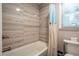 Tiled shower and tub combination with modern fixtures and natural light from a window at 111 John Christopher Dr, Alpharetta, GA 30009