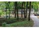 Lovely home nestled among the trees with a circular seating area and a long driveway at 111 John Christopher Dr, Alpharetta, GA 30009