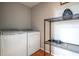 Practical laundry area with modern washer, dryer, shelving, and hardwood floors at 111 John Christopher Dr, Alpharetta, GA 30009