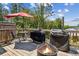 Outdoor wooden deck area with a grill, fire pit, seating, and an umbrella for shade at 243 Retreat Ln, Canton, GA 30114