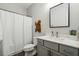 Bright bathroom with a white shower curtain, gray vanity, and a decorative wood accent at 243 Retreat Ln, Canton, GA 30114