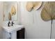 Modern powder room featuring a pedestal sink, stylish mirror, and decorative wall art at 243 Retreat Ln, Canton, GA 30114