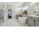 Spa-like bathroom featuring a soaking tub, marble floors, and modern fixtures at 243 Retreat Ln, Canton, GA 30114