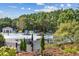 Community pool area featuring a variety of lounge chairs, umbrellas, and mature trees at 243 Retreat Ln, Canton, GA 30114
