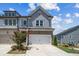 Attractive townhome showcasing gray siding, brick foundation, well-kept lawn, and a private two-car garage at 243 Retreat Ln, Canton, GA 30114