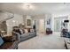 Spacious living room featuring a cozy gray sofa, plush carpeting, and staircase at 243 Retreat Ln, Canton, GA 30114