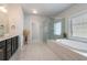 Spa-like bathroom featuring a soaking tub, separate glass-enclosed shower, and elegant vanity with modern fixtures at 2467 Davis Se Dr, Smyrna, GA 30080