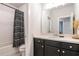Bathroom featuring dark vanity cabinets with a shower and tub combination behind a decorative shower curtain at 2467 Davis Se Dr, Smyrna, GA 30080