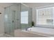 Modern bathroom with glass enclosed shower, large soaking tub, and a bright window at 2467 Davis Se Dr, Smyrna, GA 30080