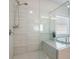 Bathroom featuring a glass-enclosed shower, soaking tub, and bright window, complemented by tiled walls at 2467 Davis Se Dr, Smyrna, GA 30080