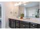 Bathroom featuring double sinks, modern fixtures, and a well-lit mirror, complemented by dark cabinets at 2467 Davis Se Dr, Smyrna, GA 30080