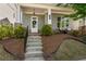 Charming front porch with gray siding, brick accents, and steps leading to a welcoming white door with a wreath at 2467 Davis Se Dr, Smyrna, GA 30080