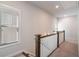 Upstairs hallway with carpet, wood railing, and natural light from a window at 2467 Davis Se Dr, Smyrna, GA 30080
