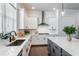 Well-lit kitchen featuring quartz countertops, an island with barstool seating, and stainless steel range hood at 2467 Davis Se Dr, Smyrna, GA 30080