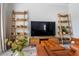 Comfortable living room with brown leather couches, decorative wooden shelves, and a modern entertainment center at 2467 Davis Se Dr, Smyrna, GA 30080