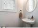 The powder room has a pedestal sink and a round mirror at 2467 Davis Se Dr, Smyrna, GA 30080