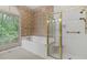 Bright bathroom featuring a tub and a glass enclosed shower with gold trim and large windows at 5510 Conway Dr, Marietta, GA 30068