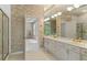 Well-lit bathroom with dual sinks, vanity, and decorative wallpaper leading to another room at 5510 Conway Dr, Marietta, GA 30068