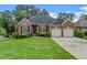 Brick home with a well-manicured lawn, two-car garage, and mature landscaping at 5510 Conway Dr, Marietta, GA 30068