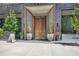 Building entrance with large wooden double doors and professionally landscaped greenery at 147 15Th Ne St # 16C, Atlanta, GA 30309