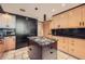 Modern kitchen features wood cabinetry, granite countertops, and black appliances at 147 15Th Ne St # 16C, Atlanta, GA 30309