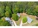 An aerial view showcases the house's location among large, mature trees and landscaped yards at 174 Cannon Pl, Dallas, GA 30157