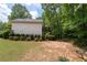 Backyard view of the home's deck and lower yard with lots of green foliage and trees at 174 Cannon Pl, Dallas, GA 30157