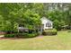 Charming home featuring lush landscaping, stone accents, and a well-manicured lawn, all nestled amongst mature trees at 174 Cannon Pl, Dallas, GA 30157