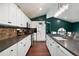 Modern kitchen featuring white cabinetry, granite countertops, and stainless steel appliances, perfect for culinary enthusiasts at 174 Cannon Pl, Dallas, GA 30157