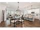 Open-concept living room featuring wood floors, modern lighting, and a spacious seating area and kitchen island at 3747 Silvery Way, Powder Springs, GA 30127