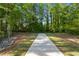 Walking path surrounded by mature trees and lush greenery, offering a peaceful outdoor experience at 3747 Silvery Way, Powder Springs, GA 30127