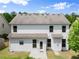 Back exterior of a two story home with white siding, a small patio and a well-manicured lawn at 3940 Village Estates Ct, Cumming, GA 30040