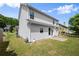 Angled view of the home's backyard, showing the siding, windows, and small patio at 3940 Village Estates Ct, Cumming, GA 30040